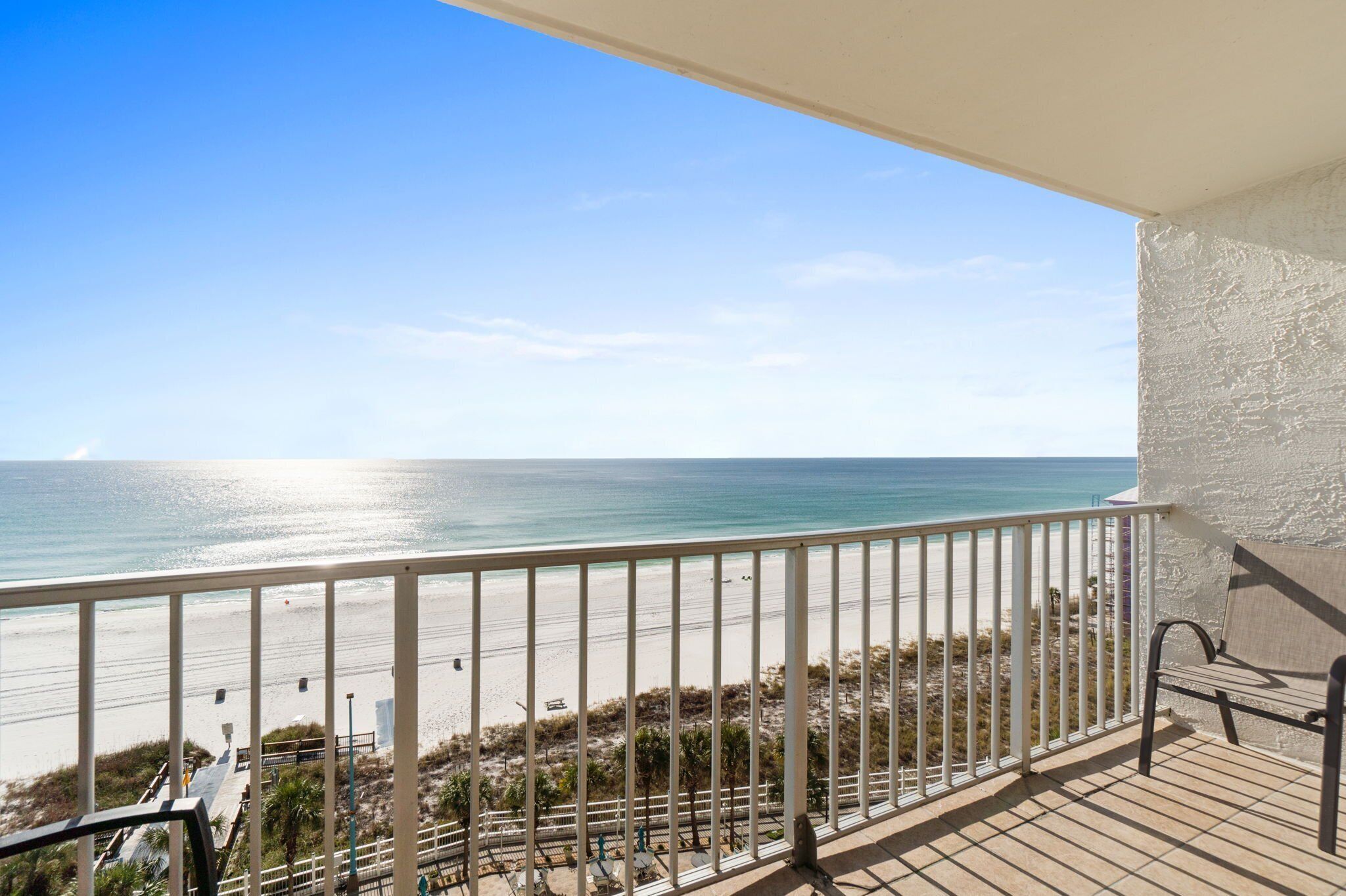 Un balcon avec vue sur la plage et l’océan.