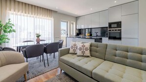 Een moderne woonkamer met een bank, stoelen en een eethoek.