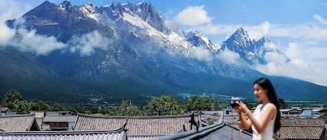 A traditional building with a view of snow-capped mountains.