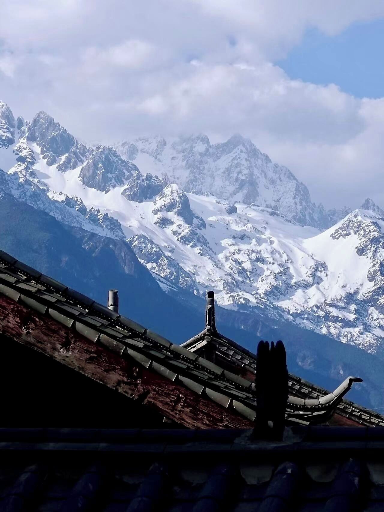Un paysage de montagne avec des sommets enneigés et un ciel dégagé.