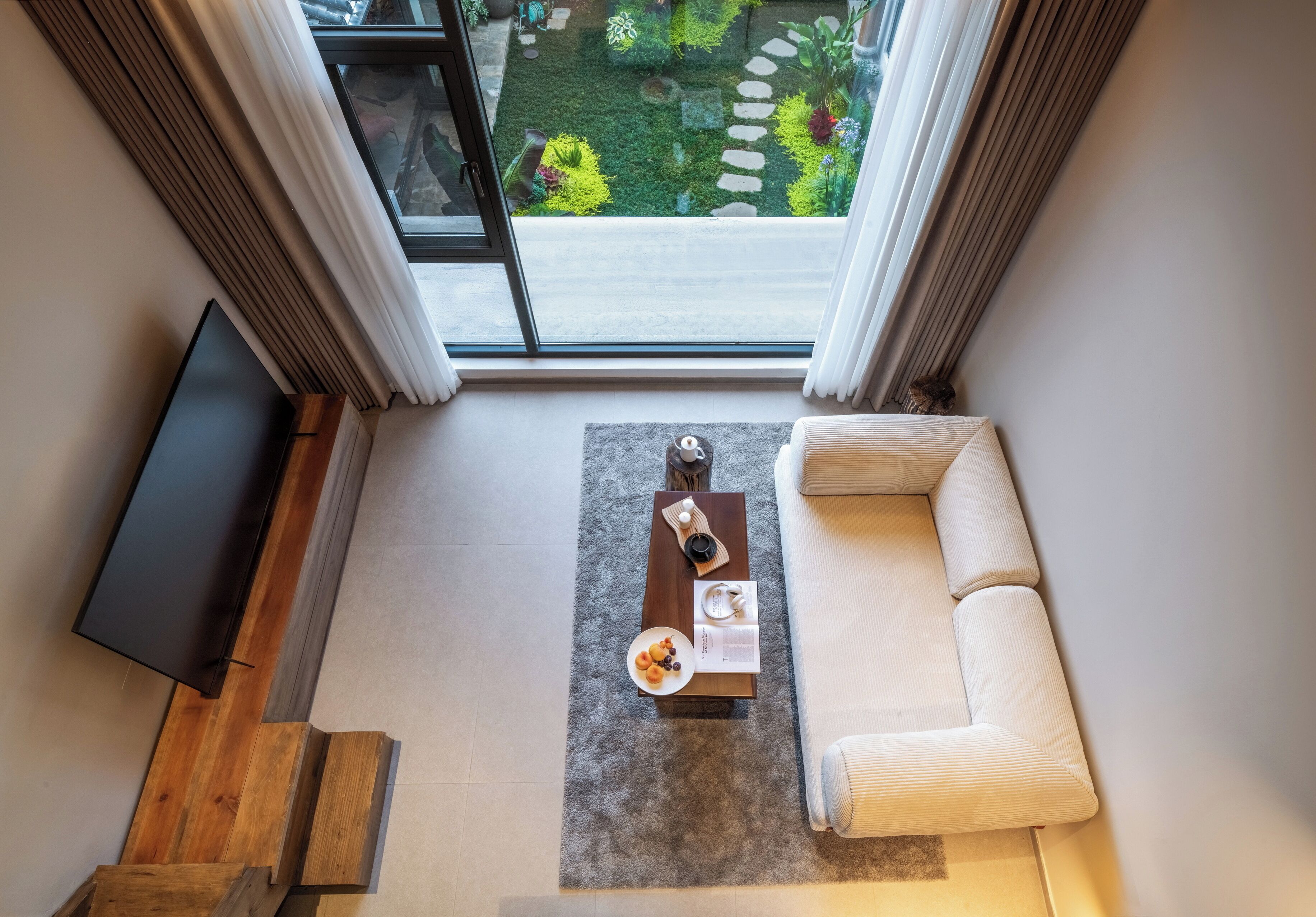 A modern living room with a sofa, a coffee table, and a flat-screen TV.