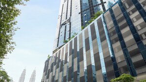 A modern building with a curved facade, large windows, and a sign reading "RESIDENCE EATON". - Eaton Residences by Sutera@klcc (Kuala Lumpur)