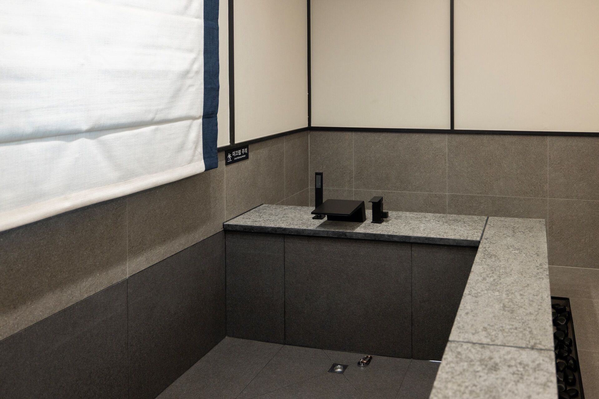 A modern bathroom with a bathtub, a shower area, and a toilet.