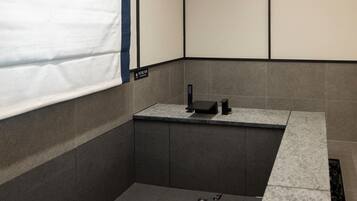 A modern bathroom with a bathtub, a shower area, and a toilet.