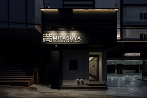 Un edificio con un letrero que dice 'MITASUYA' e 'IBY AANK'.