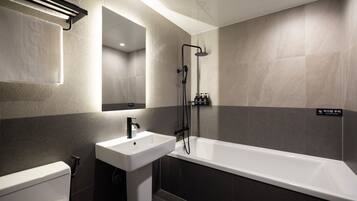 A modern bathroom with a bathtub, a sink, and a toilet.