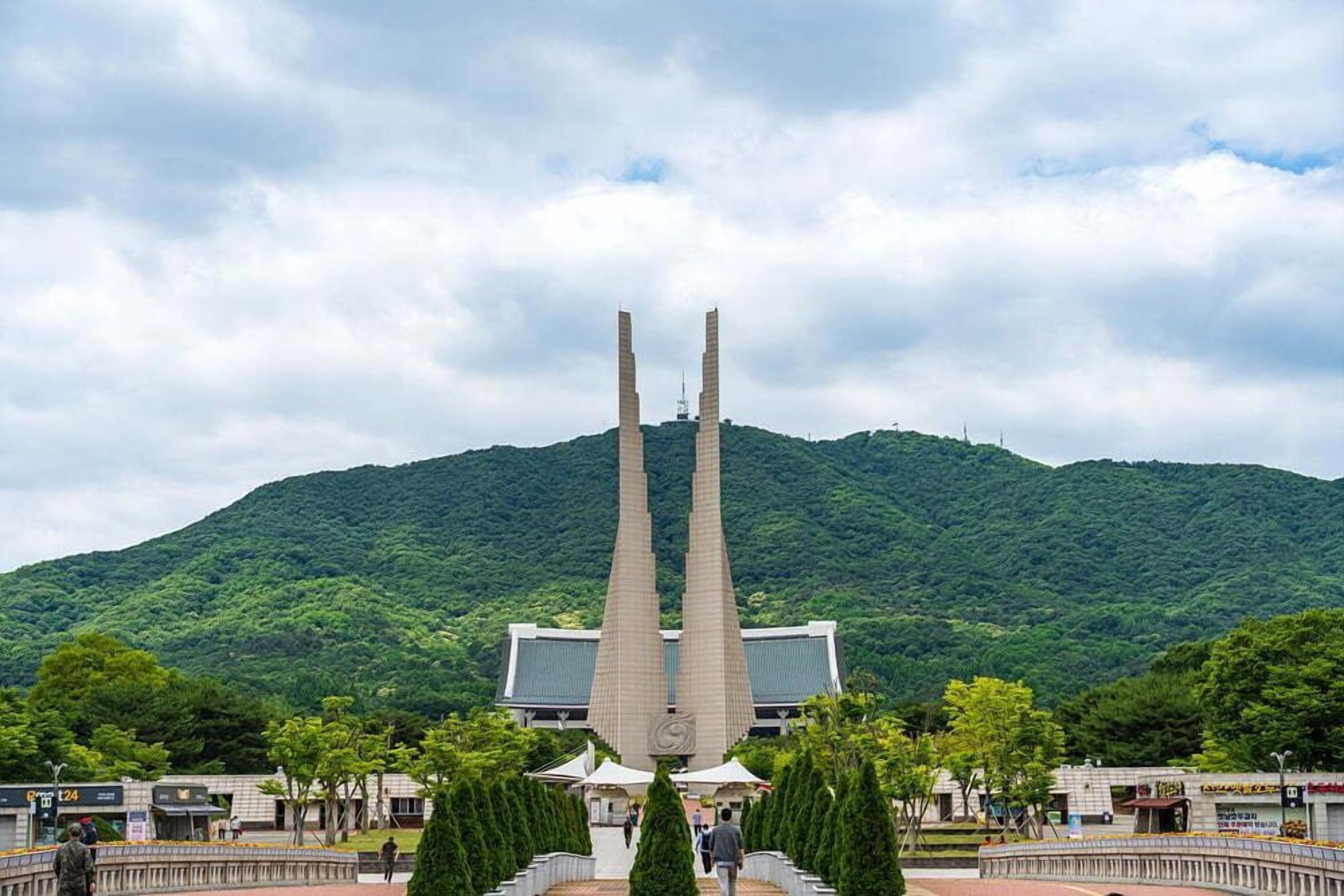 A building with a central tower and a mountain in the background.