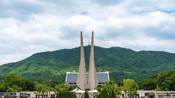 A building with a central tower and a mountain in the background.