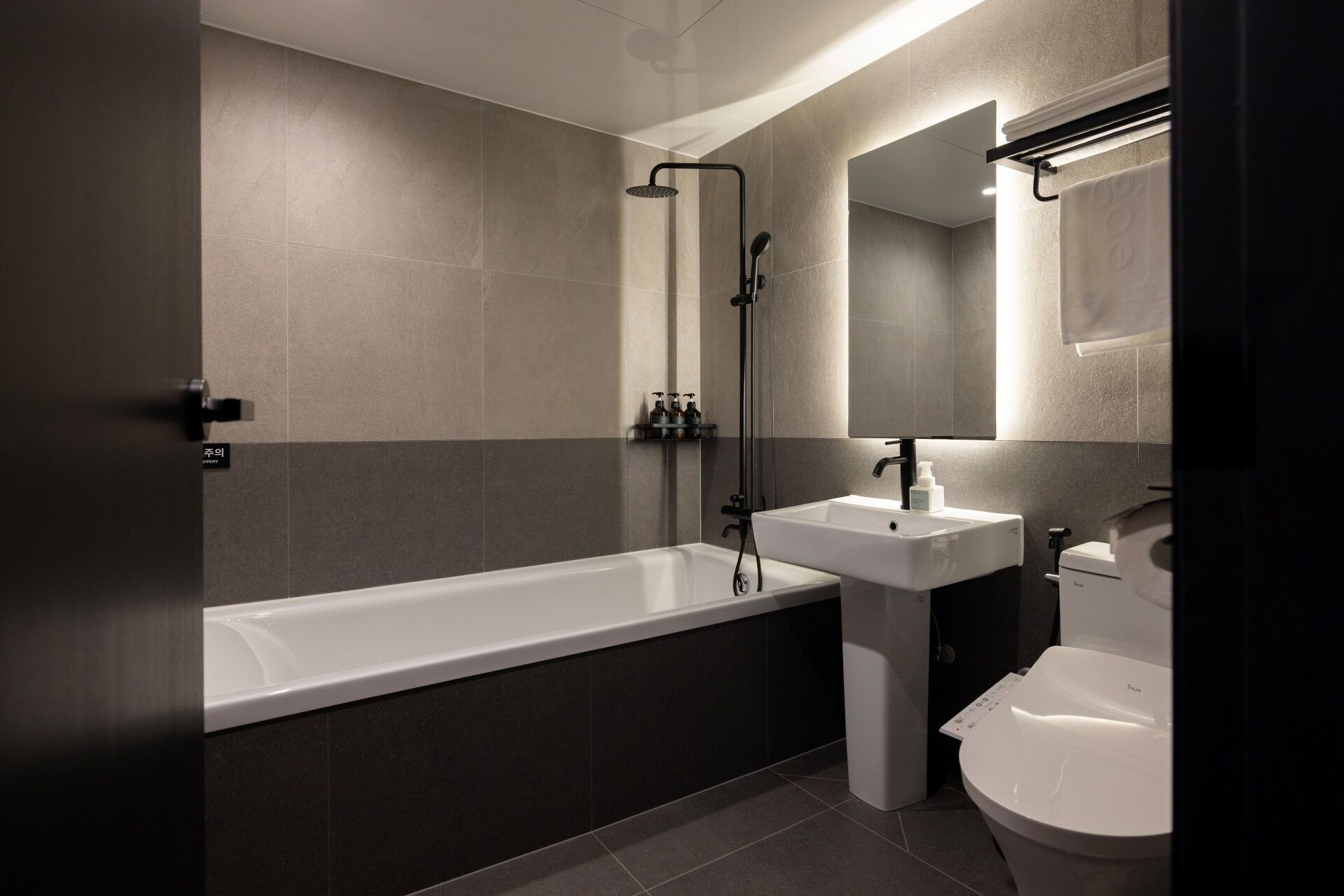 Un baño moderno con bañera, lavamanos e inodoro.