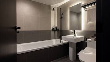 Un baño moderno con bañera, lavamanos e inodoro.