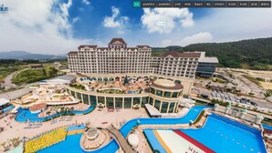 Un hotel grande con varias piscinas, un patio central y diversas comodidades.