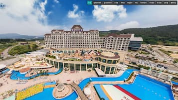 Um hotel grande com várias piscinas, um pátio central e diversas comodidades.