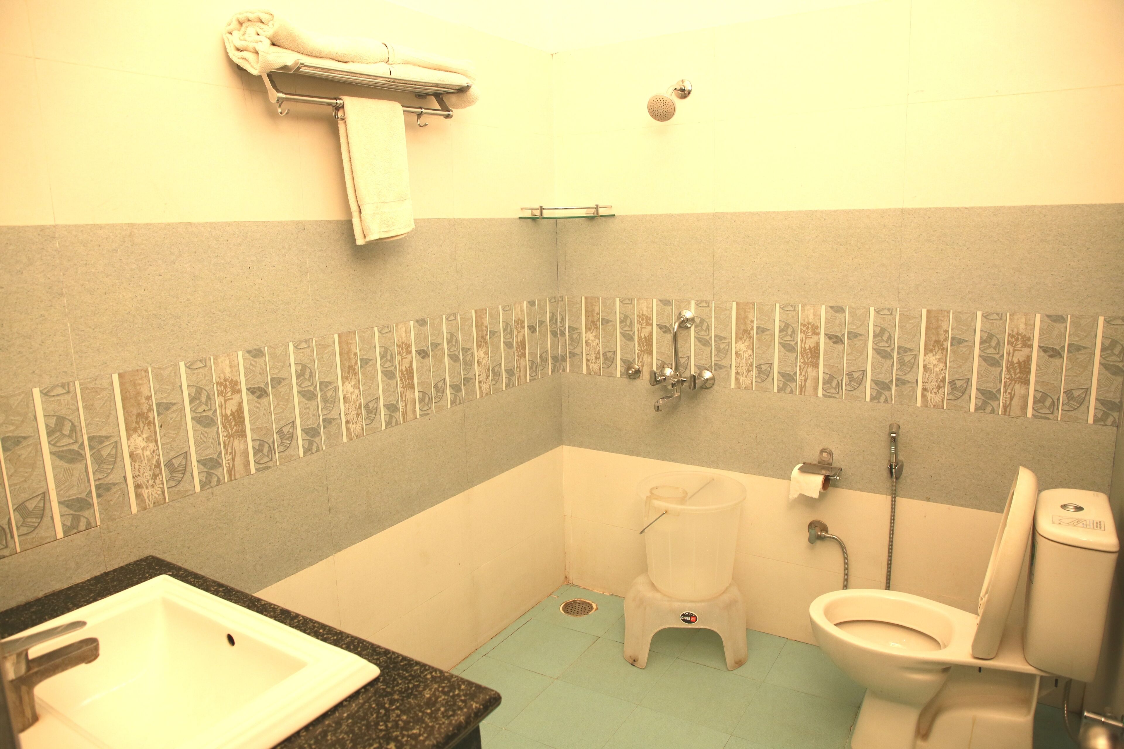 Un baño con lavamanos, inodoro y ducha.