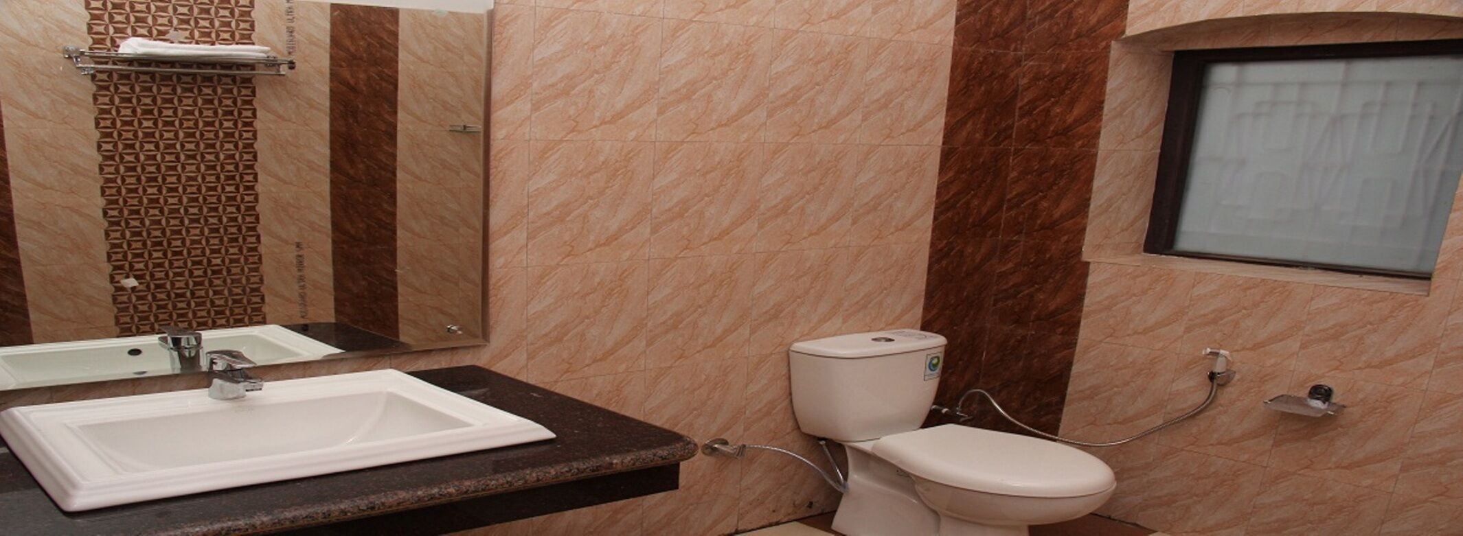 Un baño con un lavamanos blanco, un inodoro y un espejo.