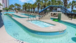 A pool area with a hot tub, palm trees, and a sign indicating a 2 ft 6 in depth. - Spacious Beach Condo Double Suite for Couples Getaway (Myrtle Beach)