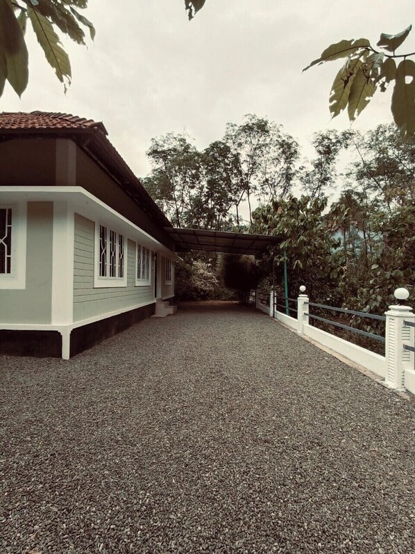 A building with a covered walkway and a gravel path leading to it.