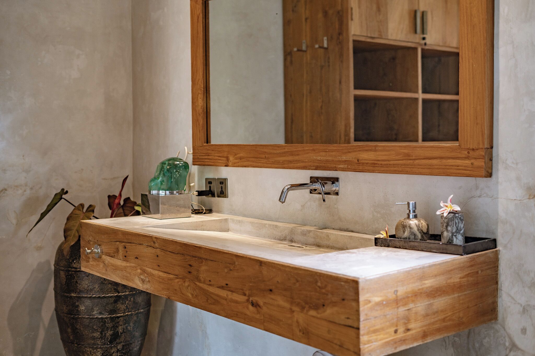 A wooden vanity with a large mirror, a sink, and a wooden cabinet below.
