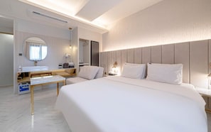 A hotel room with a large bed, a bedside table, a mirror, a wardrobe, and a bathroom area. - Signature Denbasta Hotel (Busan)