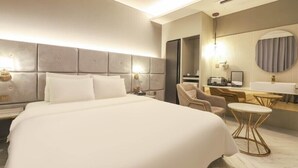 A modern hotel room with a large bed, a desk, a chair, and a round mirror. - Signature Denbasta Hotel (Busan)