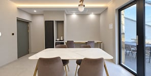 A modern conference room with a marble table, comfortable chairs, and a large window offering a view of the outdoors. - Signature Denbasta Hotel (Busan)