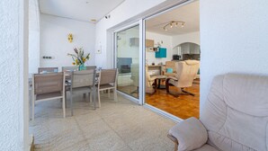 A modern kitchen with a sliding glass door leading to a dining area with a table and chairs.
