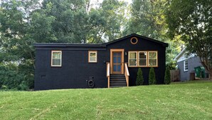 A black single-story house with a front door, two windows, and a small porch. - Marvelous 3-bedroom house with AC in Charlotte (Charlotte)