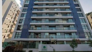 Un hôtel à plusieurs étages, doté d’une façade moderne, de grandes fenêtres et d’une entrée centrale.