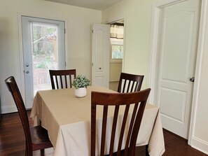 Comedor con una mesa dispuesta para cuatro personas, rodeado de sillas de madera.