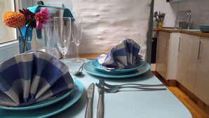 Una mesa lista para comer, con platos, cubiertos y servilletas.