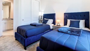 A double room with two beds, a nightstand with a lamp, a wardrobe, and a bathroom visible through an open door. - 4 Bed Villa-Sleeps 8-Pool-Gym-15 min to Disney (Kissimmee)