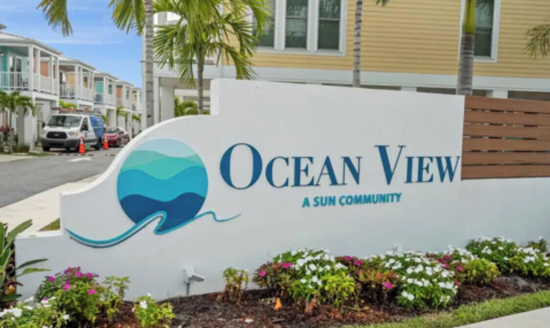 A sign for Ocean View, a Sun Community, with a logo featuring a wave and a sun.