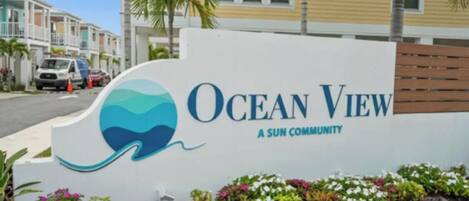 A sign for Ocean View, a Sun Community, with a logo featuring a wave and a sun.