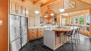 Una cocina amplia con armarios de madera, una isla grande y un refrigerador integrado.