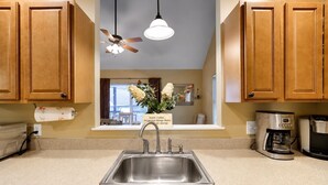 A kitchen with wooden cabinets, a stainless steel sink, a ceiling fan, and a coffee maker. - Serenity Cottage Deck, Game Room & Fire Pit near Narrowsburg Masthope (Lackawaxen)
