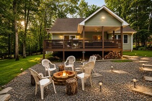 Une maison avec une terrasse, un espace salon extérieur et un foyer.