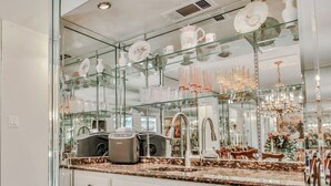 Eine Küche mit einer großen, gläsernen Vitrine, gefüllt mit dekorativen Gegenständen, einem modernen Spülbecken und einer Arbeitsplatte aus Granit.