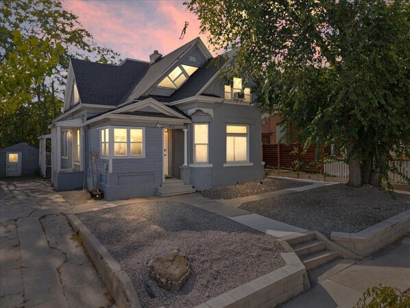 A two-story house with a front porch, a garage, and a driveway.