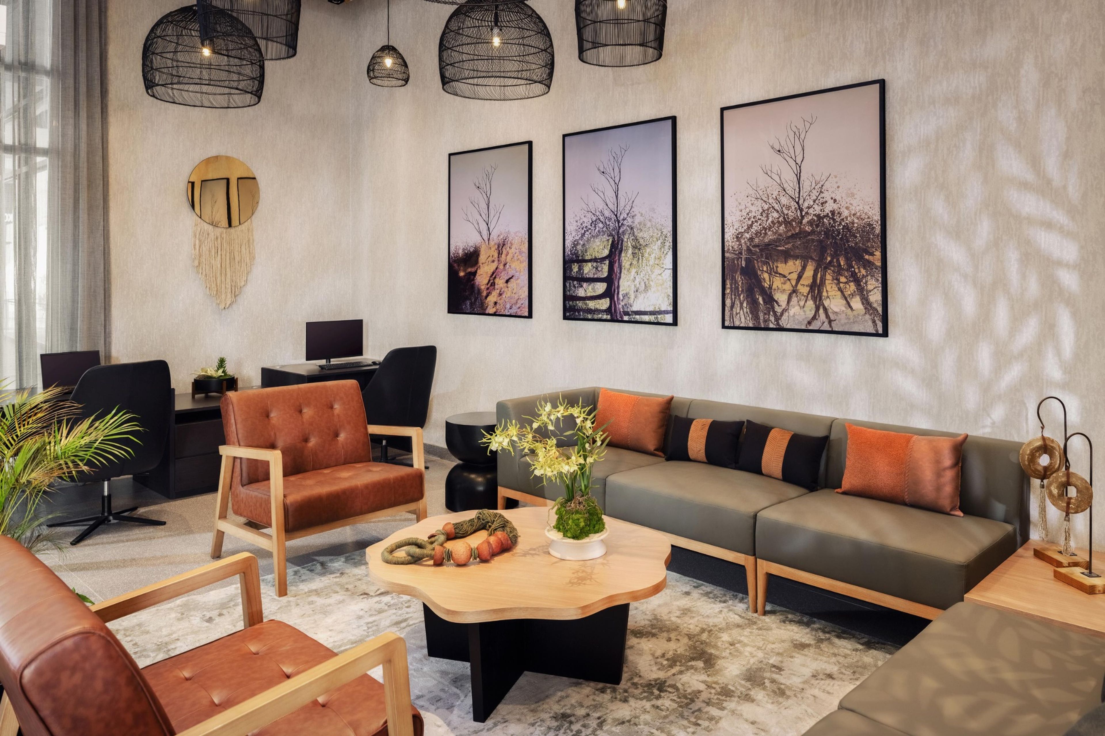 A modern living room with a sofa, chairs, a coffee table, and artwork on the walls.