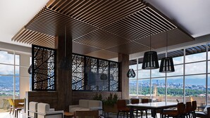 Un ampio salotto con soffitto alto, ampie finestre che si affacciano sulla città e arredamento moderno.