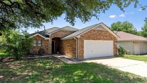 A two-story house with a brick exterior, a garage, and a covered patio area. - Spacious Home Near Coffee and Cedar Park Shopping (Leander)