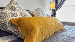 A bed with patterned pillows and a mustard-colored throw blanket. - Spacious Home Near Coffee and Cedar Park Shopping (Leander)