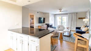 A modern apartment with a kitchen, dining area, living room, and a balcony.