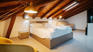 A modern bedroom with a wooden ceiling, a bed with white linens, a bedside table, and a chair. - B&B Villa Gabry  (Capo d'Orlando)