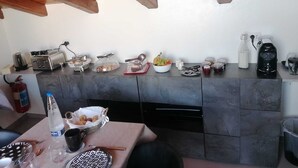 A kitchen with a wooden ceiling, a stone countertop, and various kitchen appliances and utensils. - B&B Villa Gabry  (Capo d'Orlando)