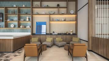 A modern lobby with a reception desk, seating area, and shelves with various items.