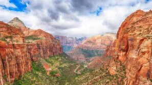 A canyon landscape with steep rock walls and a valley below.