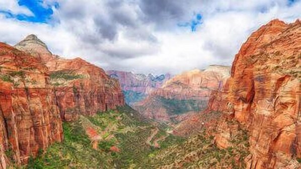 Un paisaje de cañón con paredes rocosas escarpadas y un valle en la parte inferior.