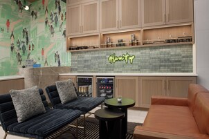 A modern lounge area with a bar, seating, and a neon sign.
