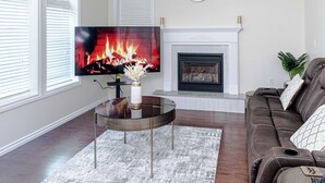 A living room with a fireplace, a television, and a sofa.
