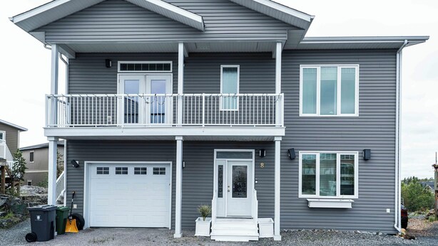 A two-story house with a front garage, a balcony, and a small porch.